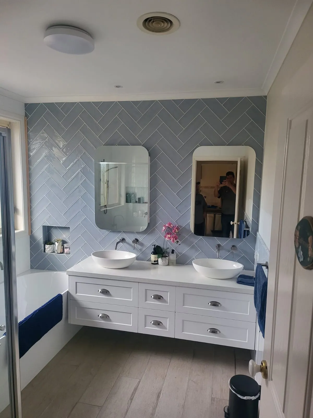 Finished Keilor East bathroom with herringbone tile wall, freestanding bath and floating vanity