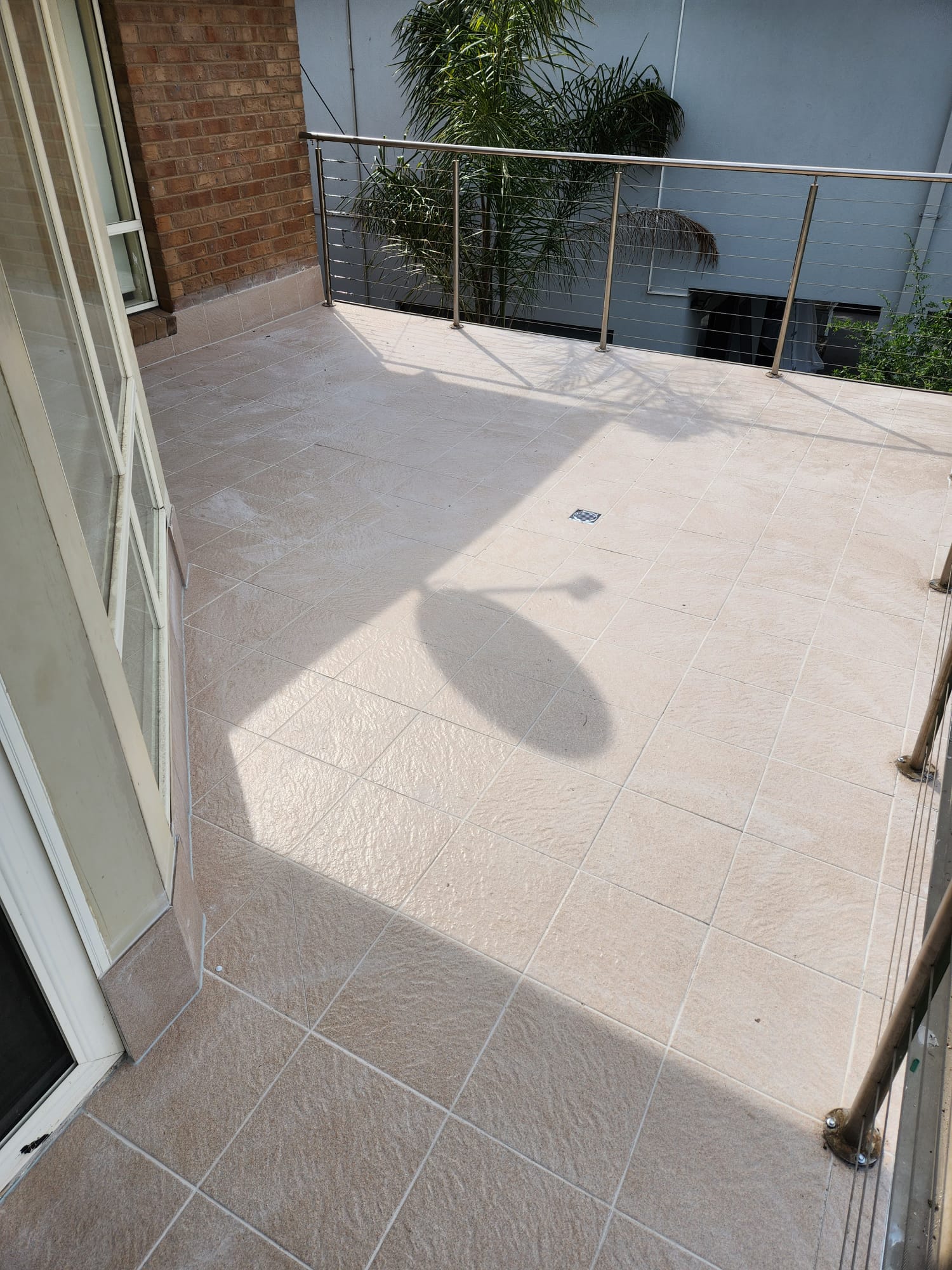 Finished balcony with new stone-look porcelain and stainless balustrade