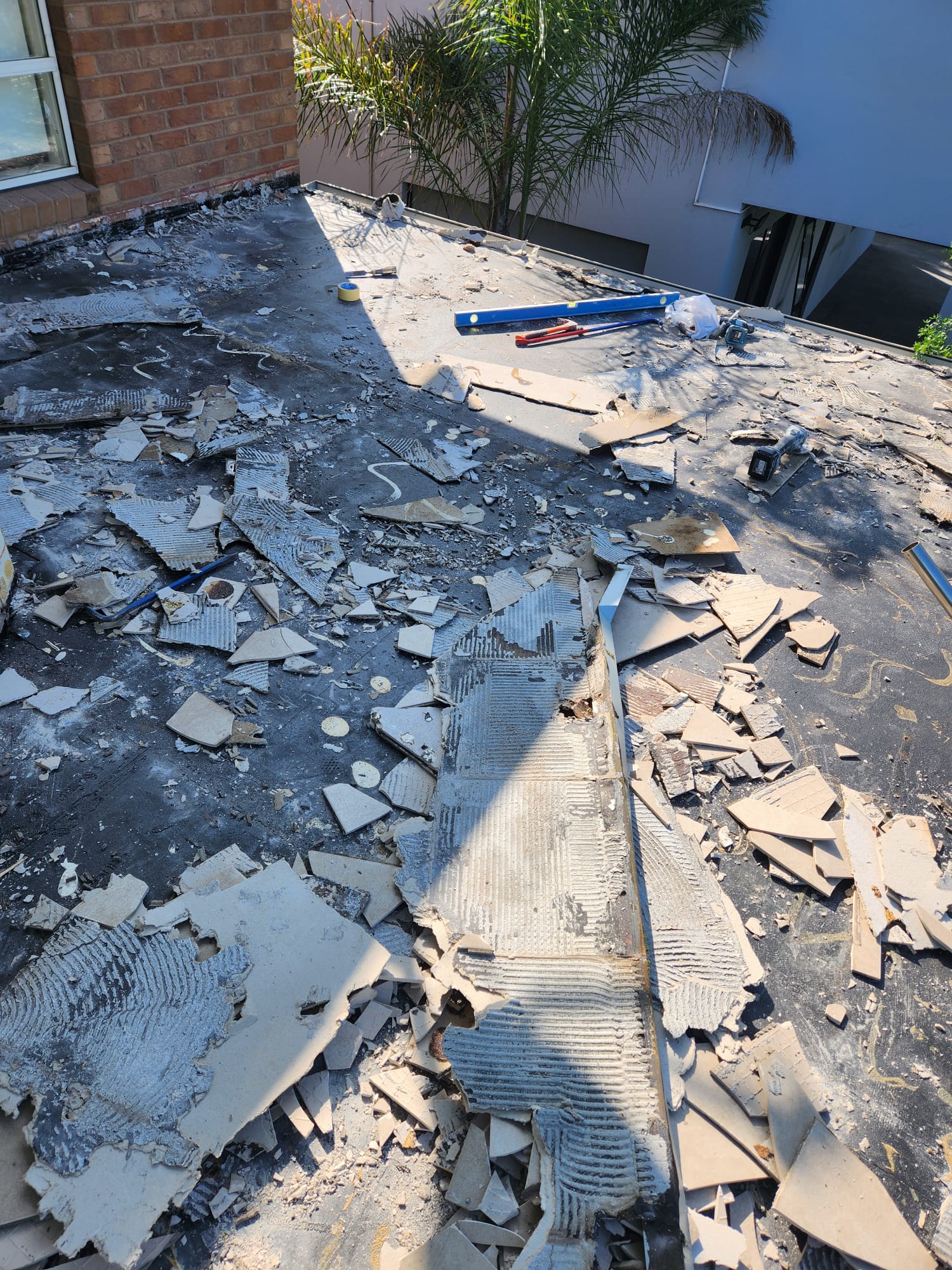 Balcony tiles fully removed exposing the waterproof membrane