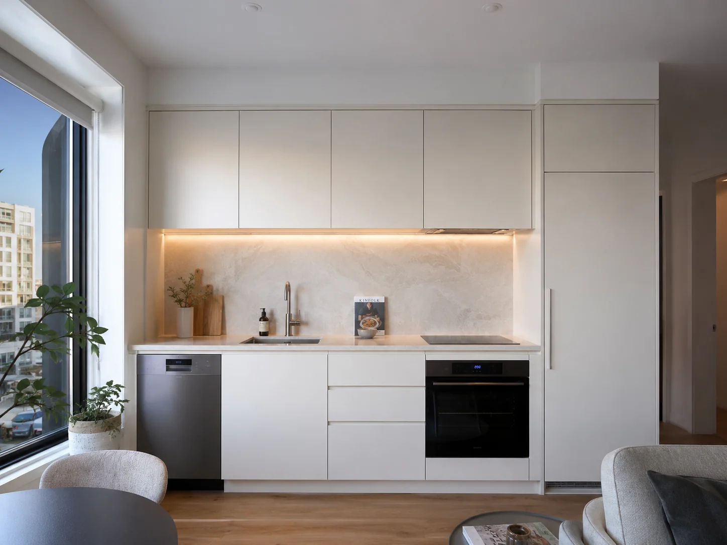 Compact apartment kitchen renovation in Geelong with integrated appliances, handleless cabinetry and stone splashback