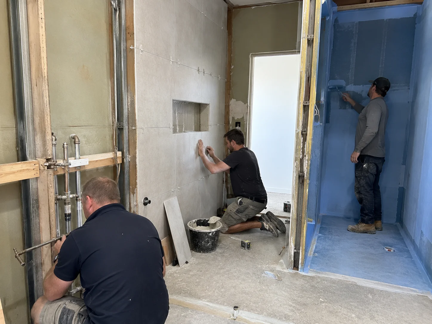 Tradespeople working on plumbing, tiling and waterproofing during a Geelong bathroom renovation