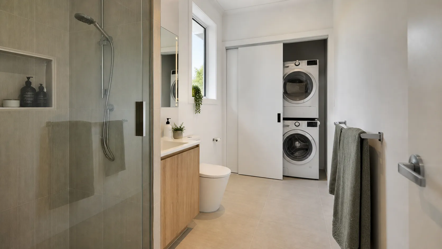 A combined bathroom and laundry zoned with the shower at one end and the machines at the other