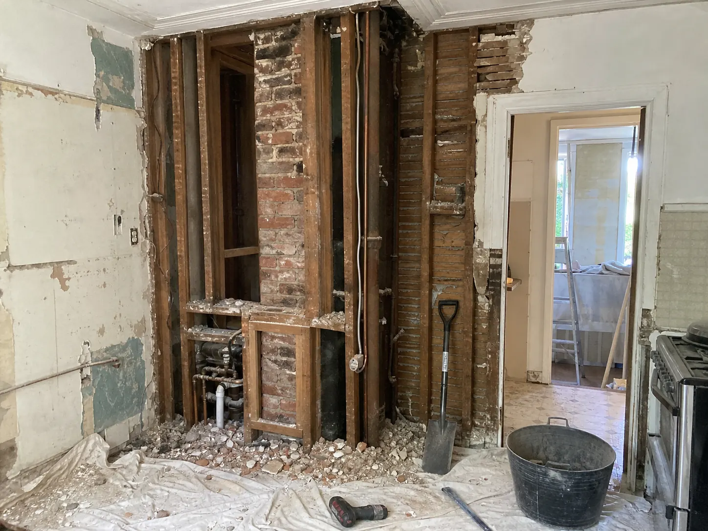 Demolition stage of a Newtown kitchen renovation revealing original services and structural elements behind plaster