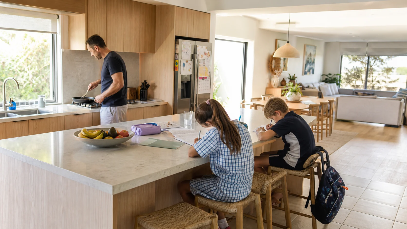 Open-plan family kitchen renovation in a Geelong home with a parent cooking while children do homework at the island bench