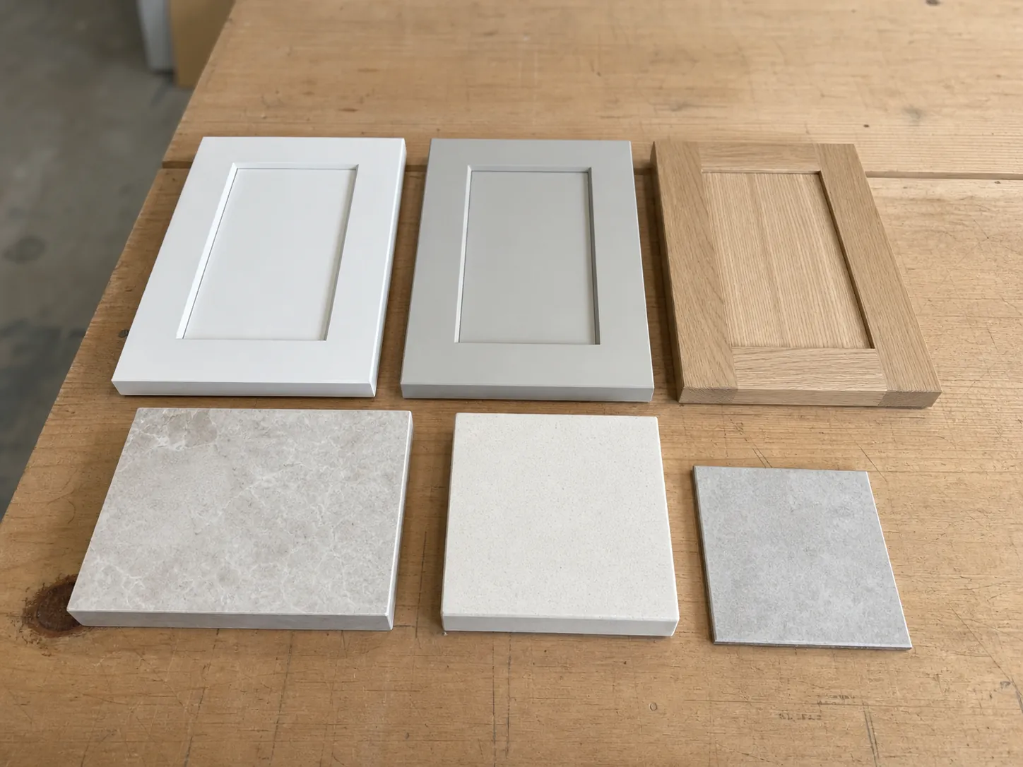 Laundry cabinet door and benchtop material samples laid side by side on a bench