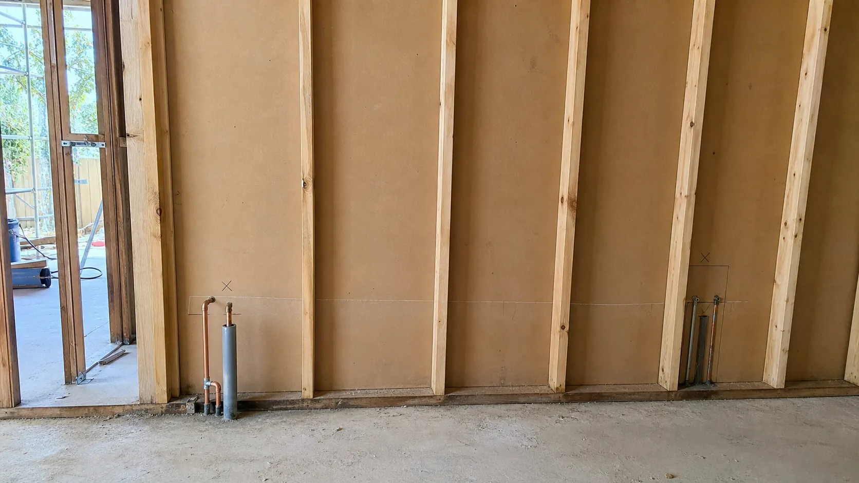 Laundry wall showing existing tap and waste positions with the route a relocated waste pipe would take to a new position