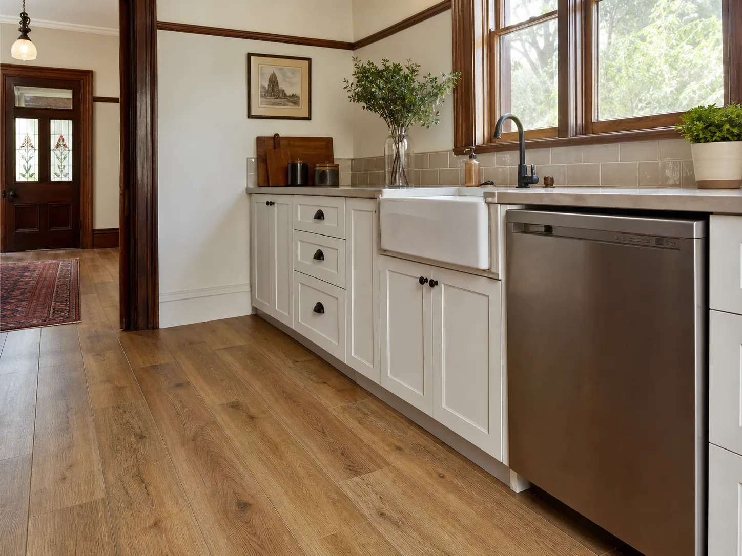 Timber-look flooring in a period-home kitchen matching original hallway floorboards, with waterproofed flooring near the sink