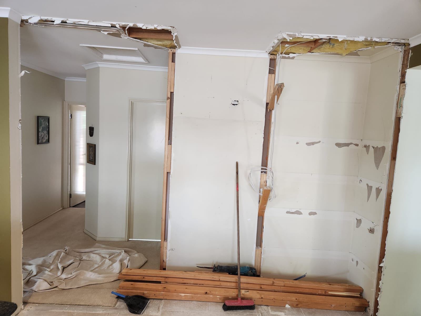 Ceiling and wall opened up showing exposed framing and electrical