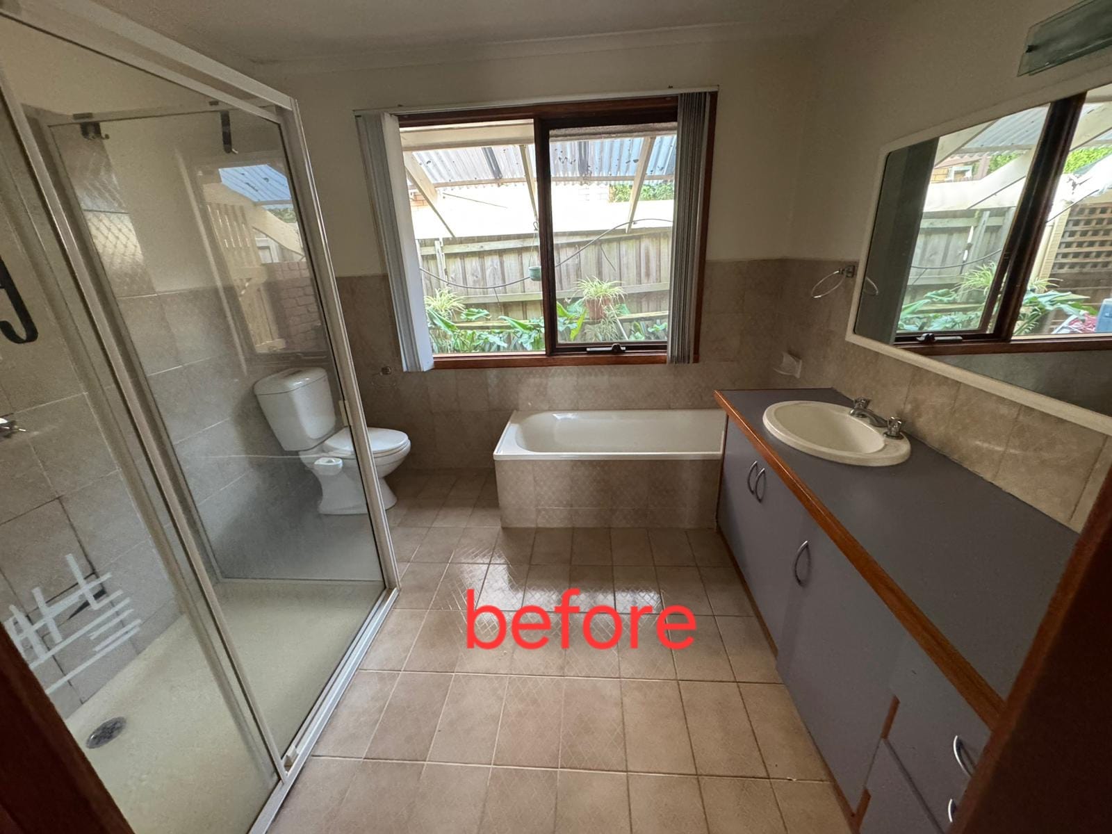 Original Templestowe bathroom before renovation, with dated tiles and a framed shower screen